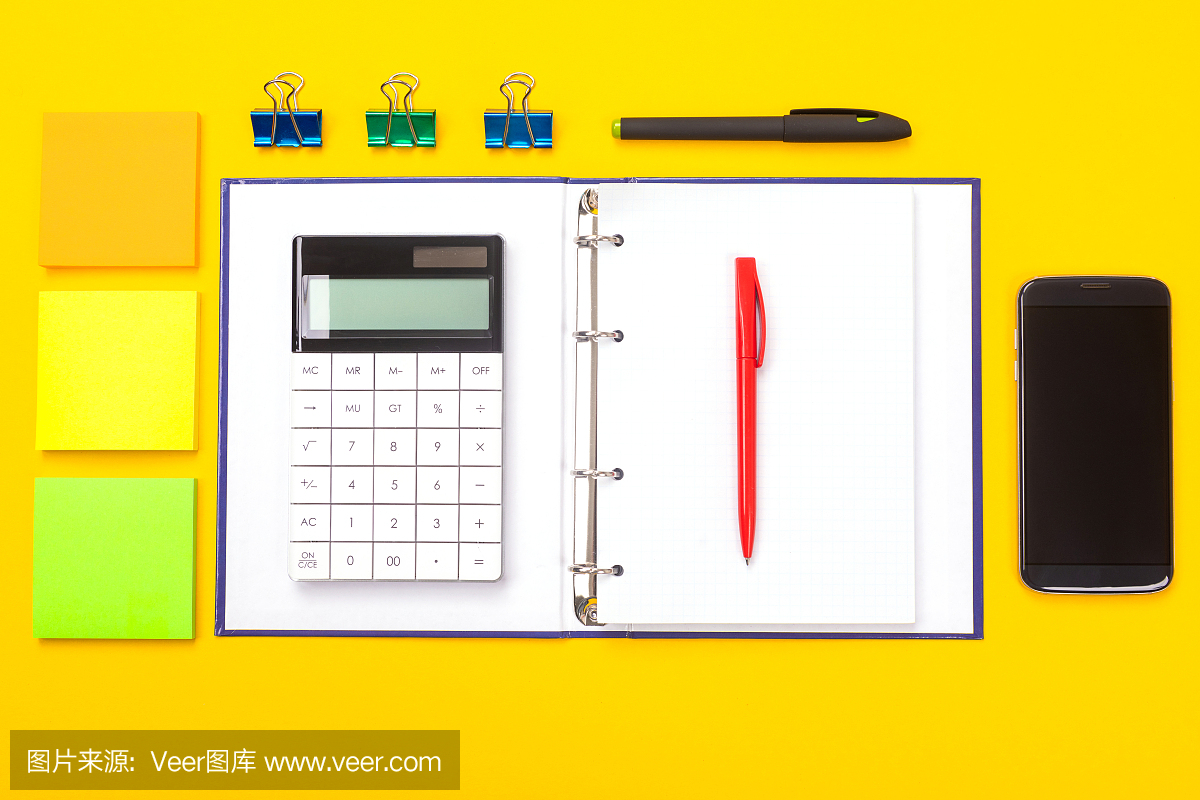俯視圖的工作空間桌子與手機,筆記本和鋼筆孤立在黃色的背景